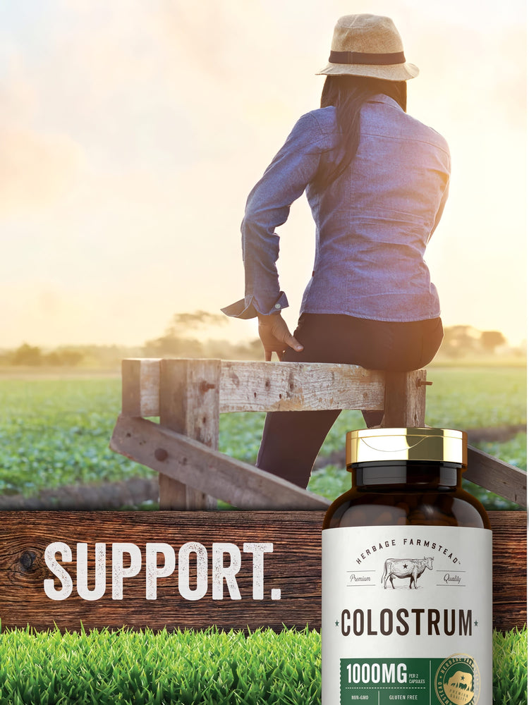 An adult woman sits on a wooden fence in a field, with the text 'SUPPORT' and a bottle of Herbage Farmstead Colostrum.