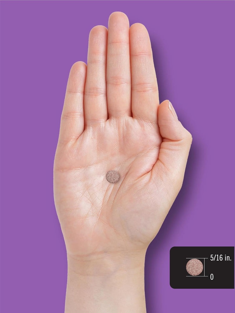A round tablet measuring 5/16 inch in diameter rests on a person's palm.