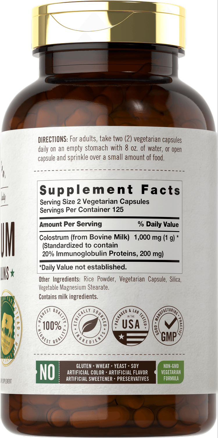 Carlyle Colostrum 1000 mg Vegetarian Capsules displayed in a dark brown bottle on a hand scale.