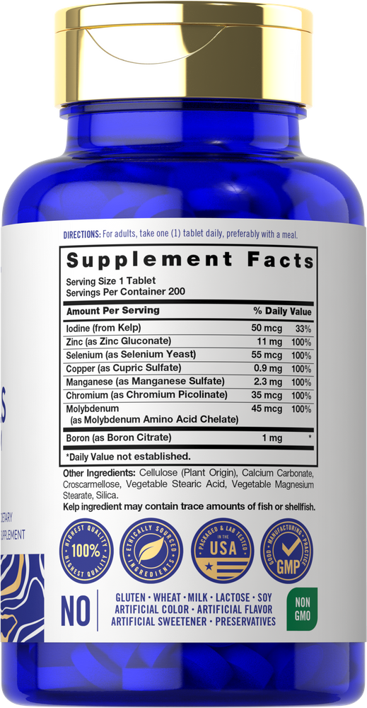 A hand holding a bottle of Trace Minerals 200 tablets, photographed on a bulk scale for measurement accuracy.
