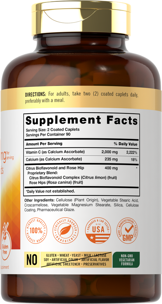 Hand holding coated caplets with 2000 mg Vitamin C and 400 mg Citrus Bioflavonoid and Rose Hip blend.
