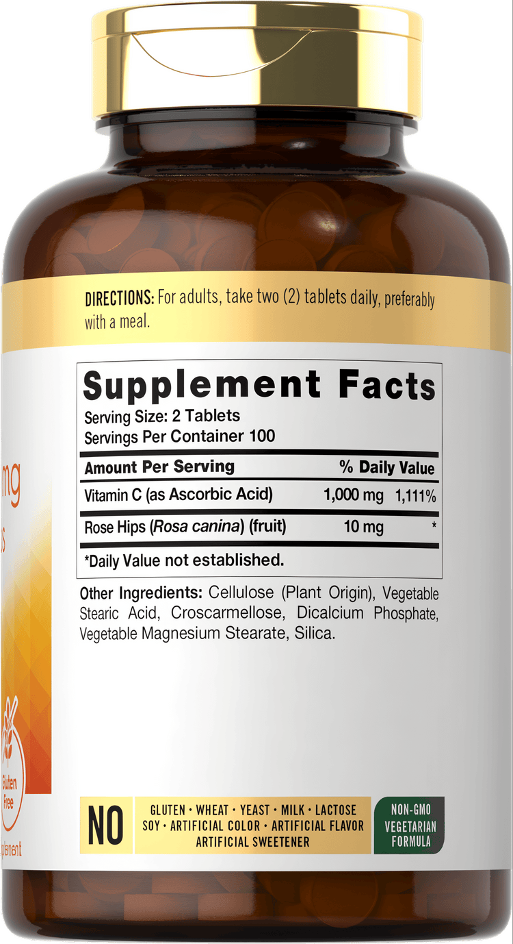 Bulk scale image of many light brown 500 mg Vitamin C tablets scattered on a surface.