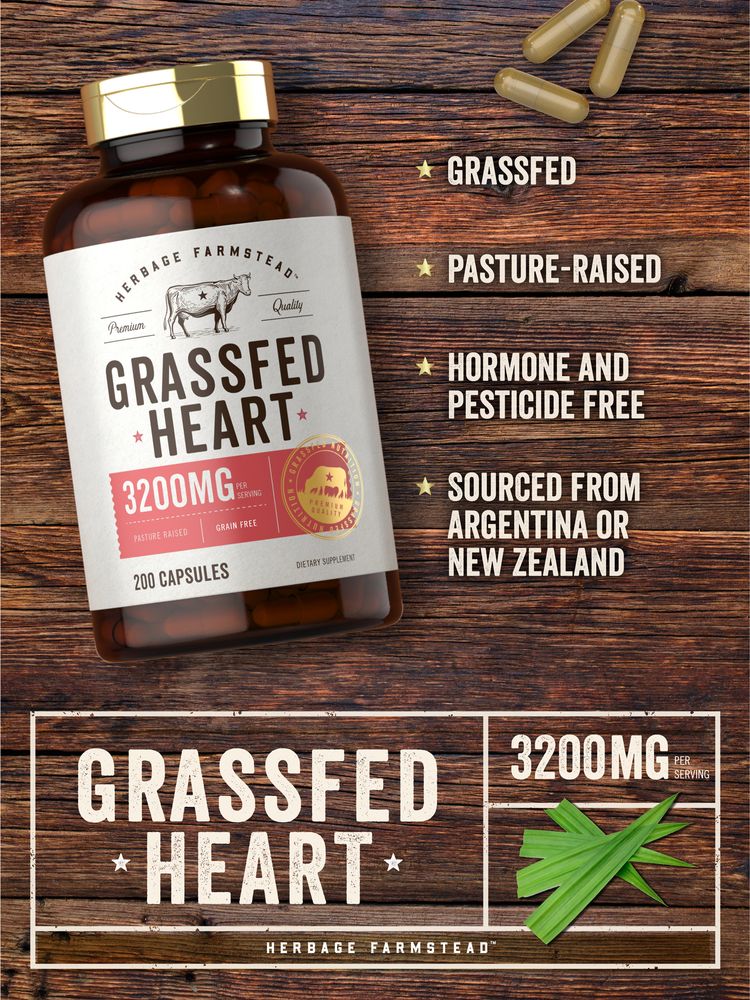 A hand holding three light brown Carlyle Grass Fed Heart 3200mg capsules, showcasing their size and color for supplement description.