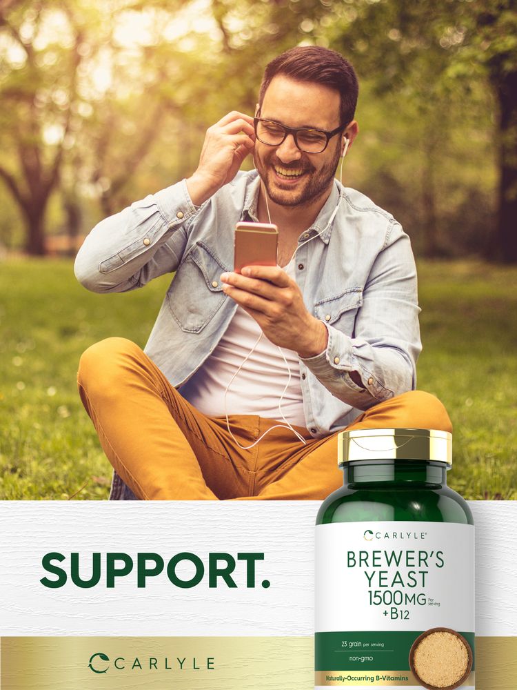 Young man laughing, listening to music outdoors with a Carlyle Brewer's Yeast bottle in hand.