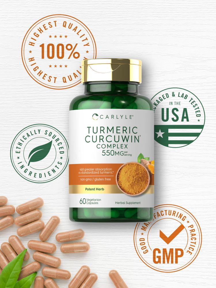 Light brown Turmeric Curcuwin Complex 550 mg vegetarian capsules scattered on a white surface with green leaves.