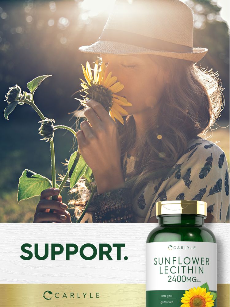 A young woman in a hat smells a sunflower, holding a bottle of Carlyle Sunflower Lecithin.