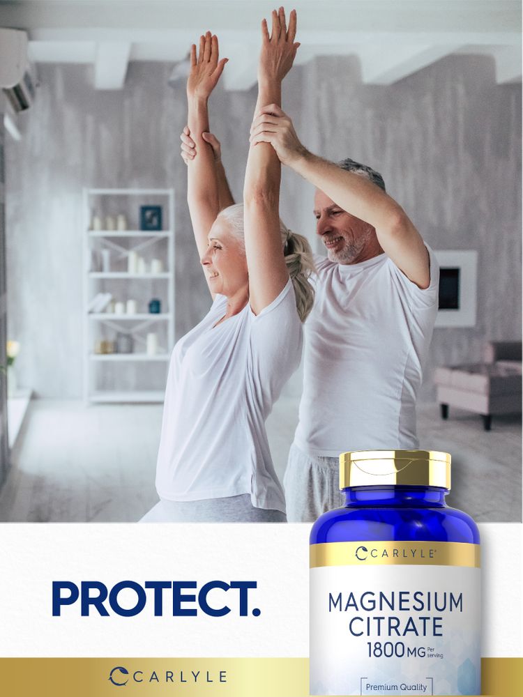 Senior couple performing arm stretches in yoga with a Carlyle Magnesium Citrate bottle nearby.