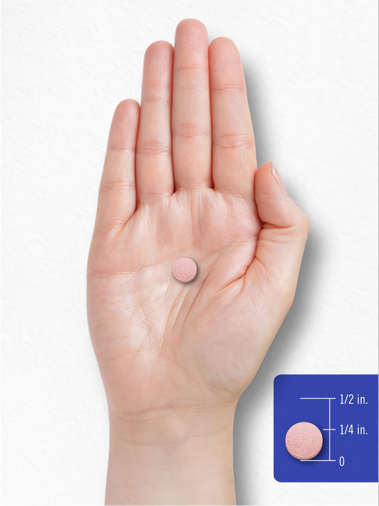 A pink tablet rests on a person's palm with a visible scale marking of 1/4 inch and 1/2 inch.