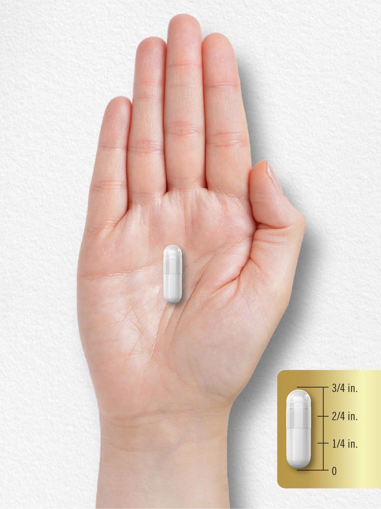 A white capsule rests on a hand, measuring three-fourths of an inch.