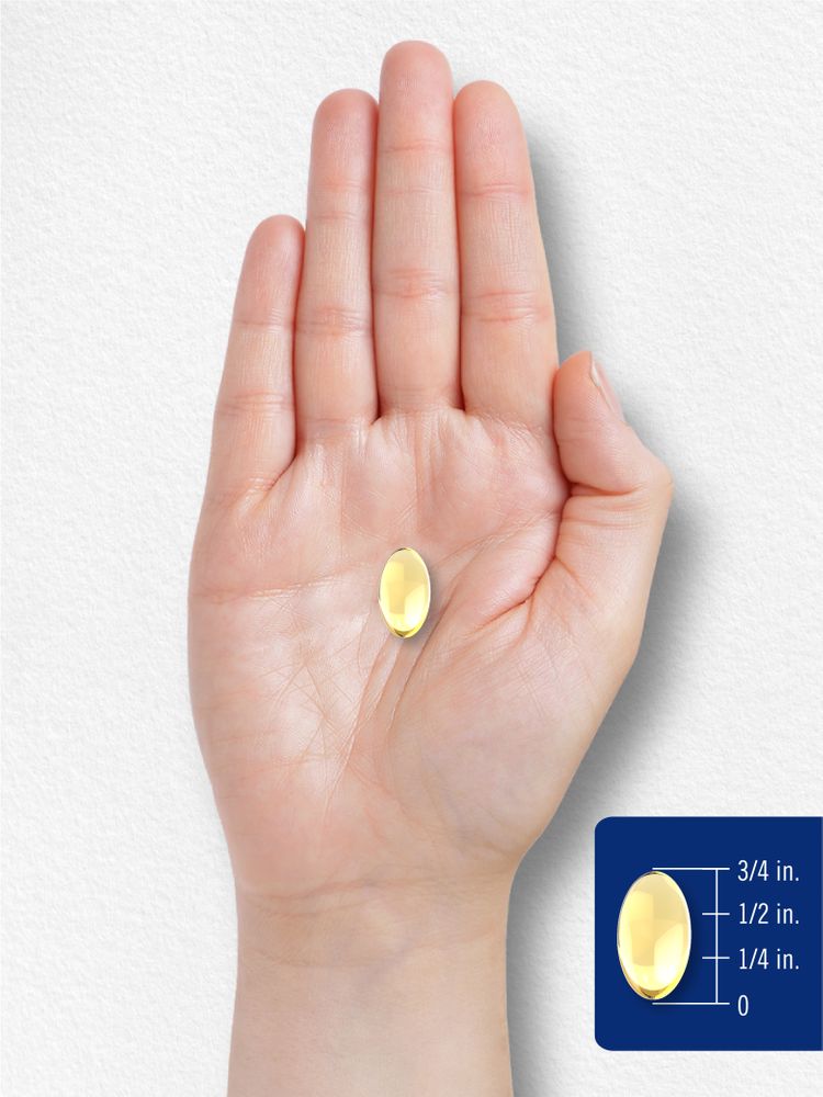 A yellow oval softgel capsule, approximately three-quarters of an inch long, used for scale reference on a hand.