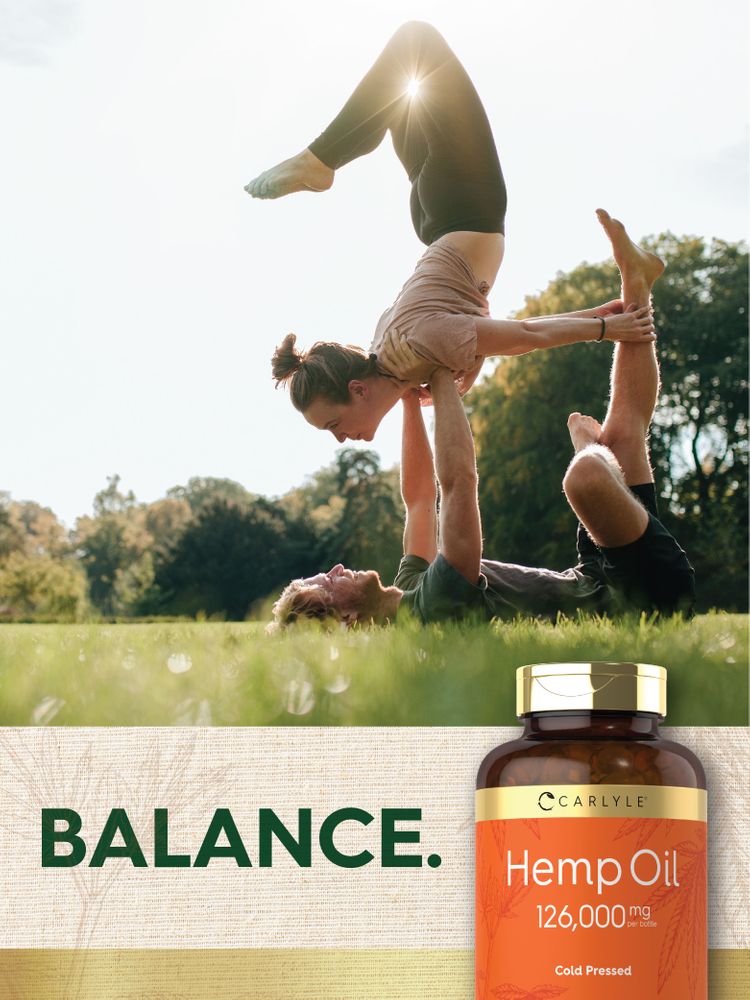 Young man and woman perform acro-yoga outdoors, balancing each other, beside a Carlyle Hemp Oil bottle and 'BALANCE.' text.