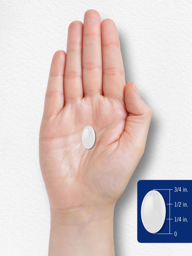 A 3/4 inch white oval softgel on a bulk scale, captured in hand scale view, emphasizing the softgel's size and shape.