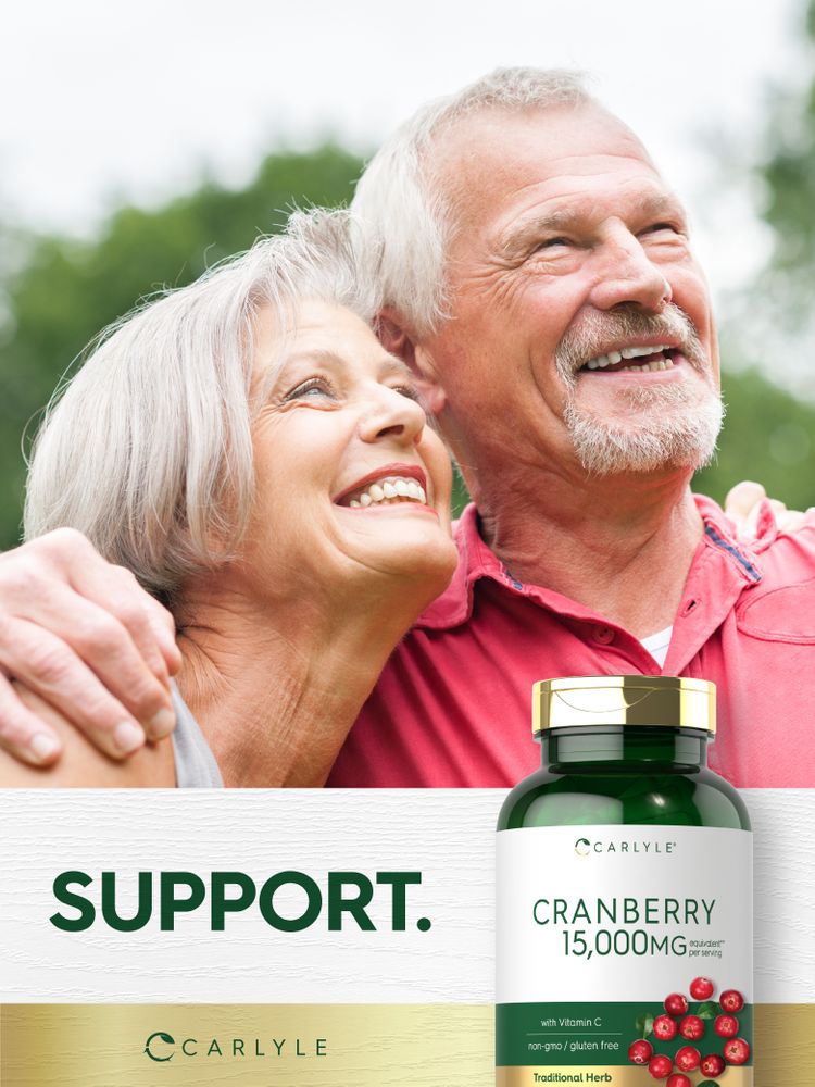 Older man and woman smiling outdoors holding a Carlyle Cranberry 15,000MG supplement bottle.