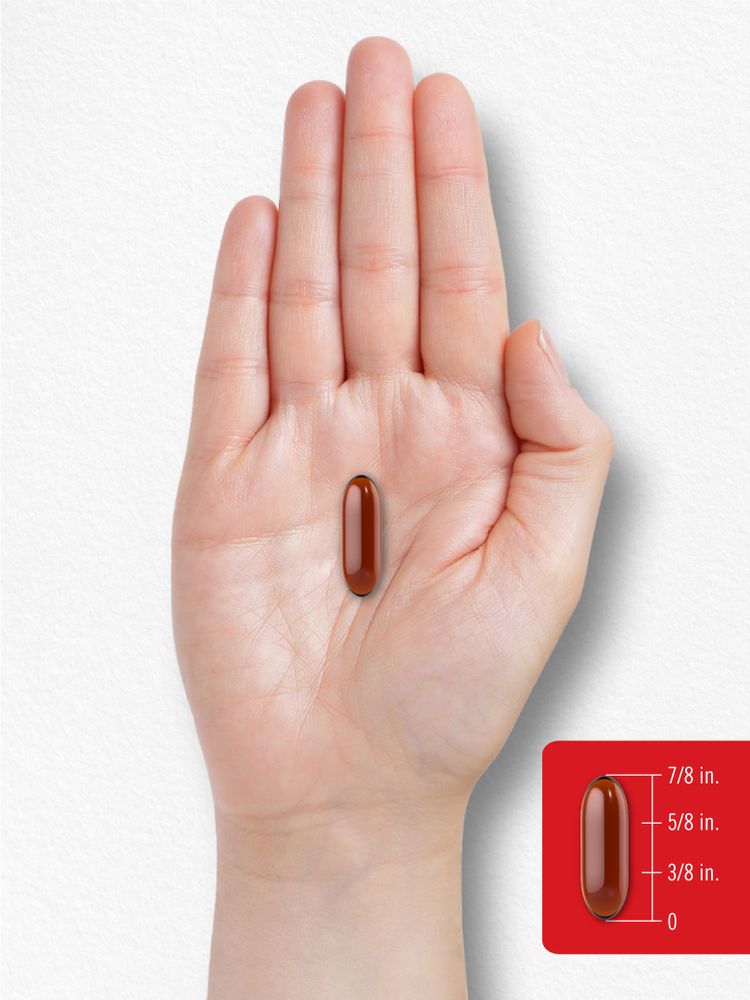 A softgel capsule is measured at 7/8 inch on a scale held by a hand.