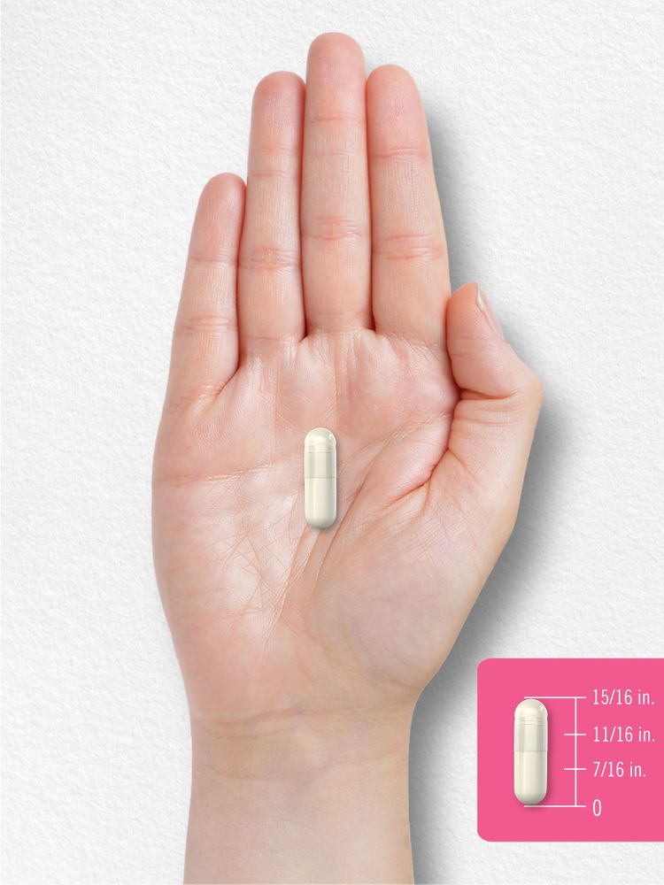 A hand holds a capsule measuring 15/16 inches.