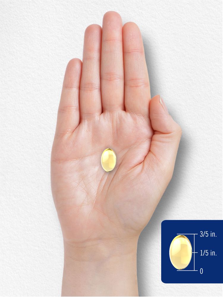 An oval yellow softgel, 3/5 inch long by 1/5 inch wide, rests in a person's palm.
