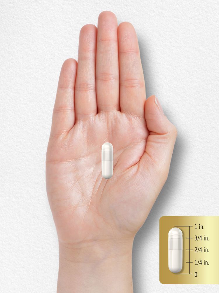 A white capsule measuring 3/4 inch long against a hand or scale backdrop.