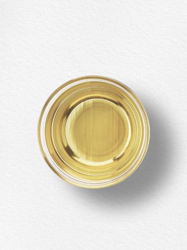 A clear glass bowl filled with yellow Vitamin E oil.