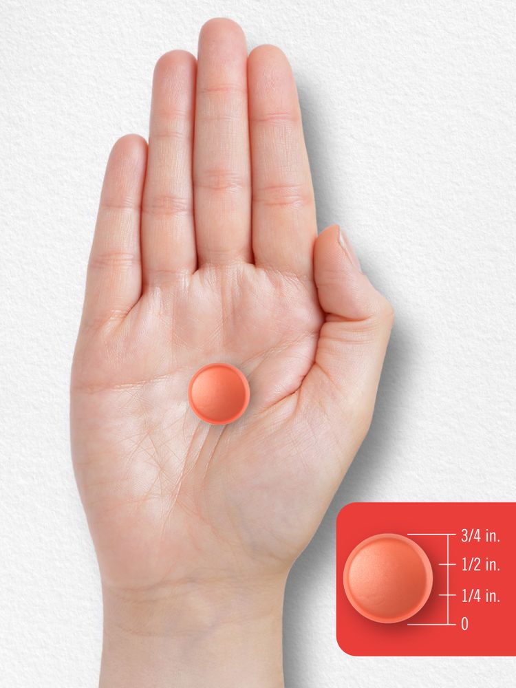 A hand holds an orange gummy, 1/2 inch in diameter, to show its size and scale.