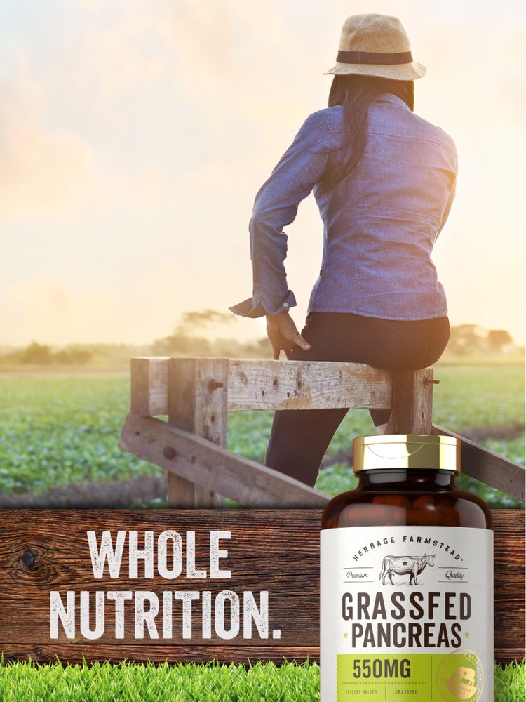 Woman sitting on a wooden fence, gazing at a sunset field, with a Grassfed Pancreas bottle beside her.