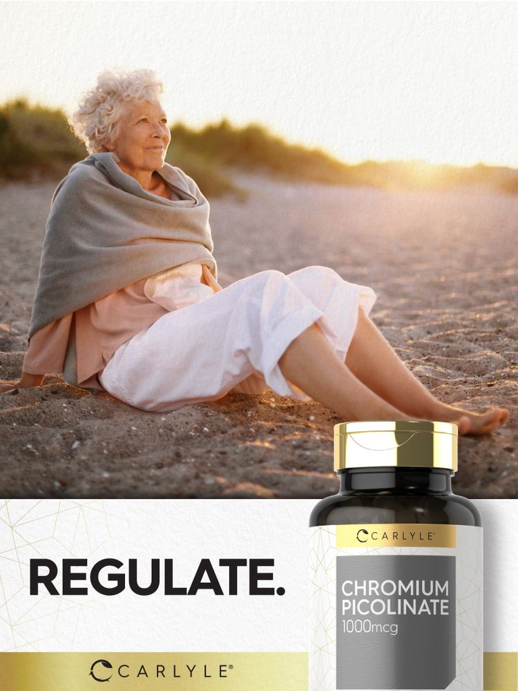 Elderly woman sitting on a sandy beach at sunset, wrapped in a blanket, with a Carlyle Chromium Picolinate 1000mcg bottle.