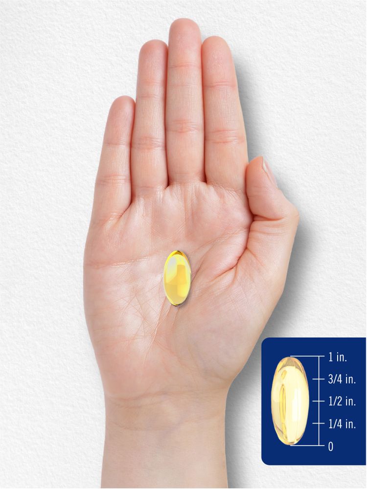 A single, yellow softgel capsule, approximately 1 inch long, displayed on a hand scale for measurement.
