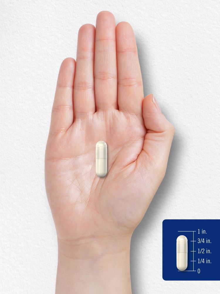 A 3/4 inch capsule rests on an open palm, illustrating size.