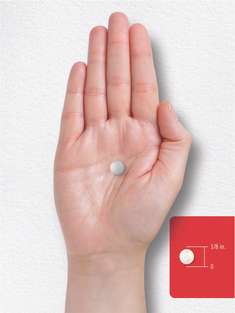 A small white round tablet, about 1/8 inch in diameter, rests in the palm of a hand, illustrating scale.
