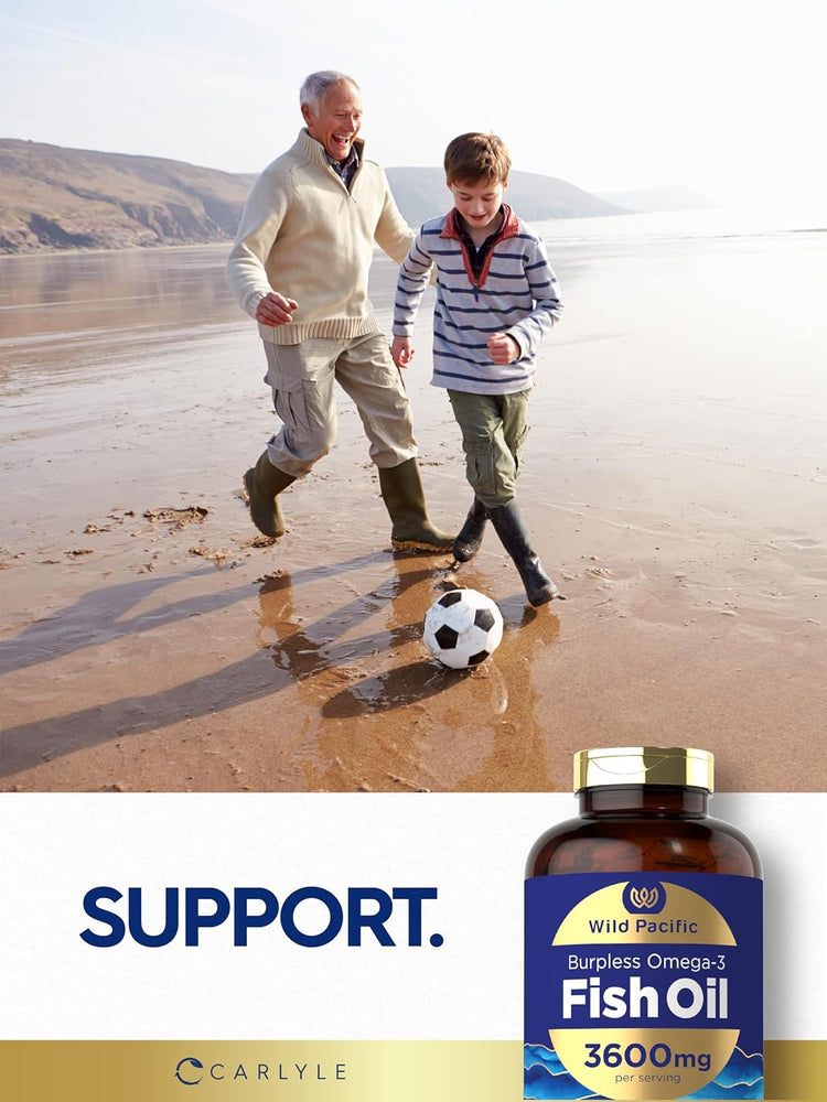 An older man and a young boy play soccer on a beach next to a bottle of Carlyle Fish Oil.