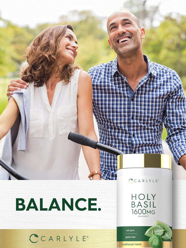 A smiling couple holds bicycles outdoors, displaying a Carlyle Holy Basil 1600 mg bottle.