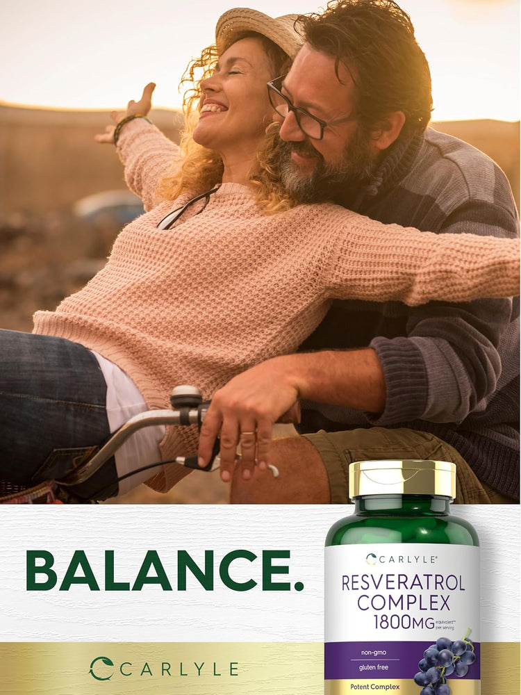 A smiling middle-aged couple rides a bicycle at sunset, with a Carlyle Resveratrol Complex bottle visible.