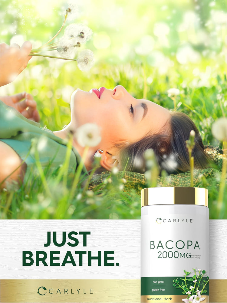 A young woman lies in the grass holding dandelions next to a Bacopa supplement bottle.