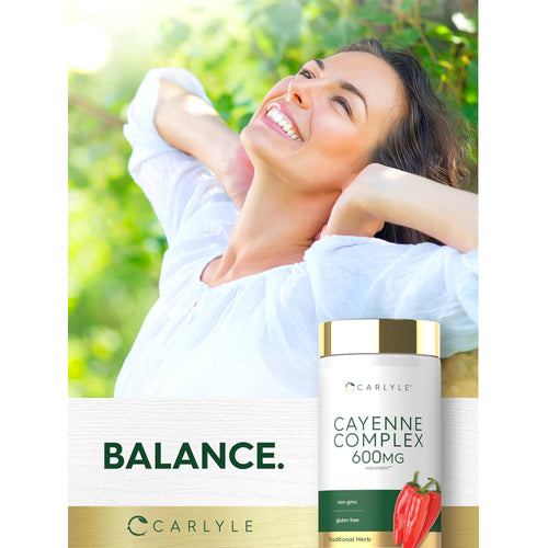 View 6 A woman smiles at the sun outdoors, holding a Carlyle Cayenne Complex 600 mg bottle.