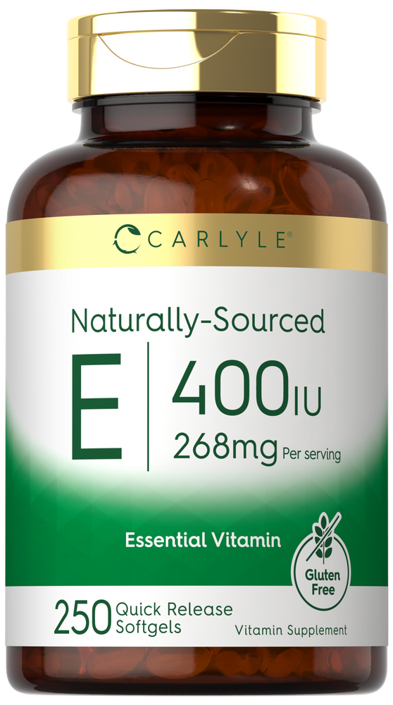 Hand holding Carlyle Naturally-Sourced Vitamin E Softgels, 400 IU 268mg bottle with clear label and softgels visible inside.