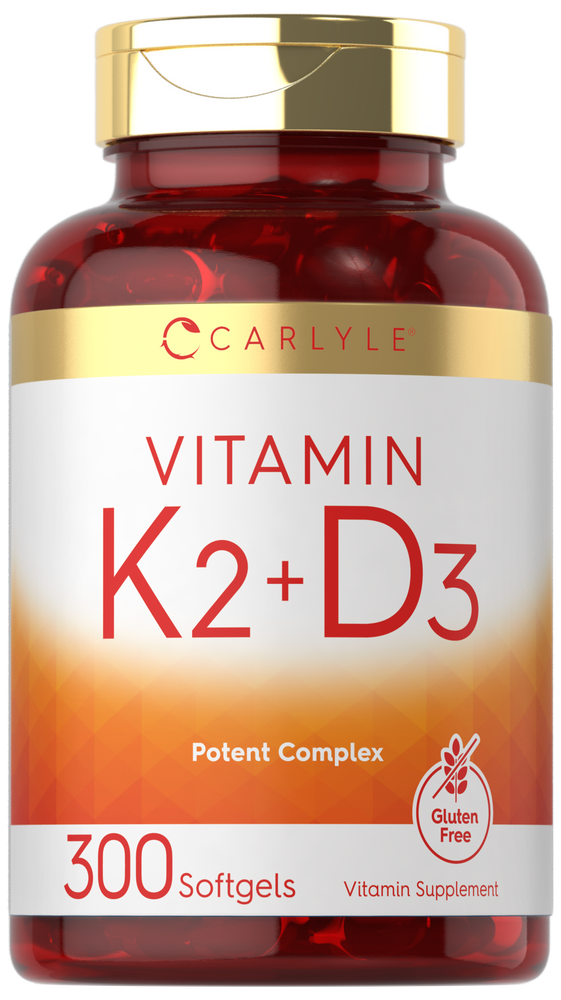 Carlyle Vitamin K2 + D3 supplement with 300 softgels, shown on a hand scale, indicating its bulk size.