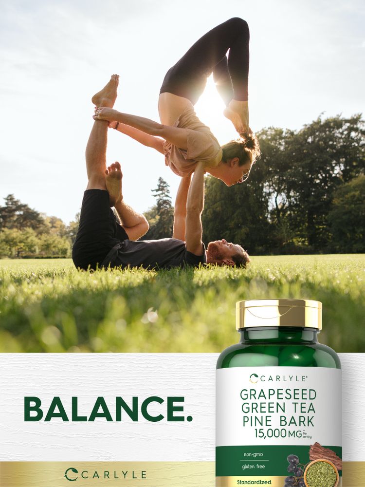 Two young adults practicing acro yoga in a park with a Carlyle Grapeseed Green Tea Pine Bark bottle nearby.