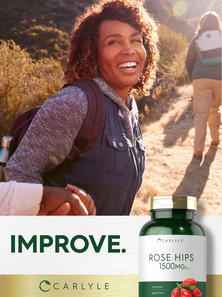 Smiling middle-aged African American woman hiking on a sunny trail, holding hands with another person, beside a Carlyle Rose Hips bottle.