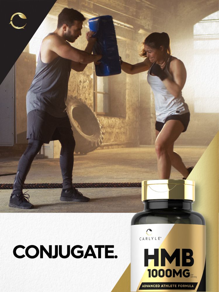 A man holds a pad for a woman punching, with a Carlyle HMB bottle visible in the foreground.