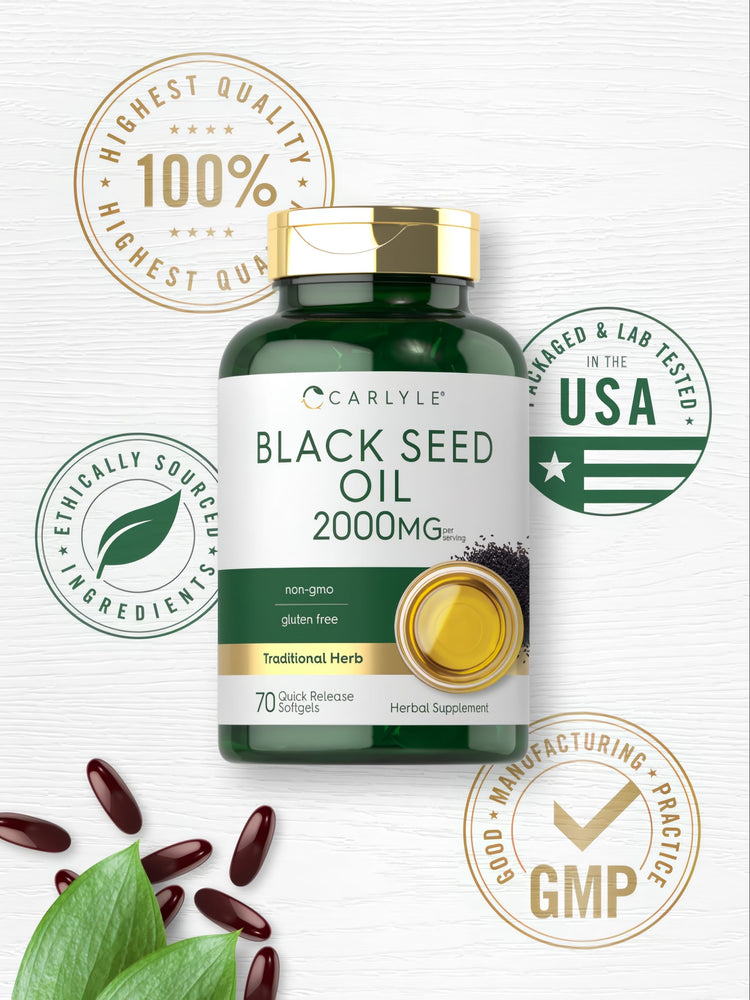 A collection of dark red-brown softgels scattered across a surface with green leaves, highlighting natural health supplements.