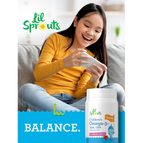 View 6 A young girl happily looks at her phone while a Lil' Sprouts Children's Omega-3+ bottle sits nearby.