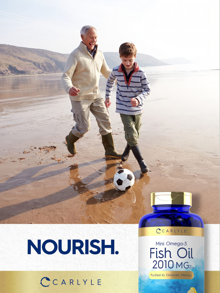 Older man and young boy play soccer on a beach with a Carlyle Fish Oil bottle nearby.