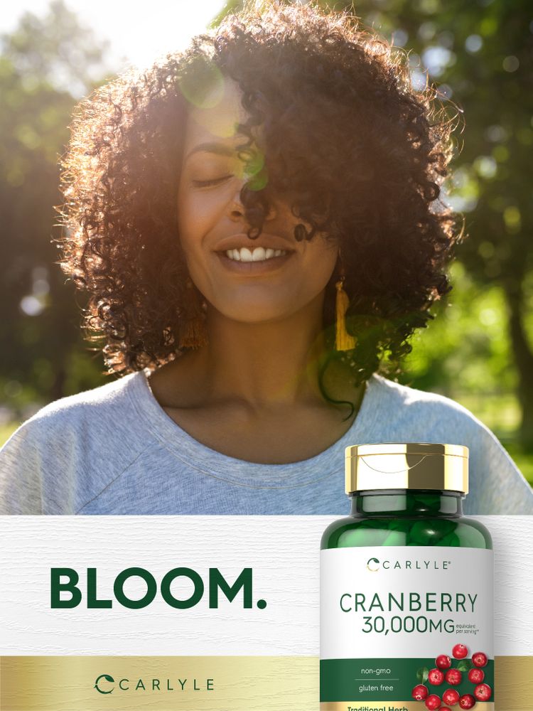 An adult African American woman smiles with eyes closed outside, next to a bottle of Carlyle Cranberry 30,000mg.