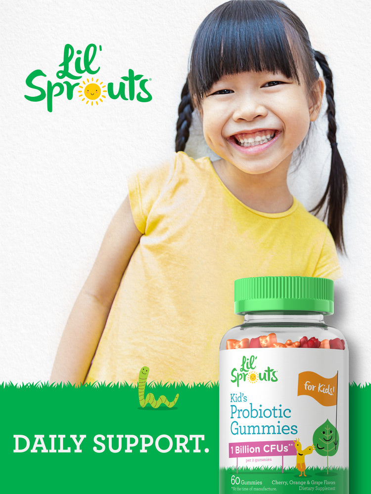 A smiling girl with pigtails in a yellow shirt holds a bottle of Lil' Sprouts Kid's Probiotic Gummies.