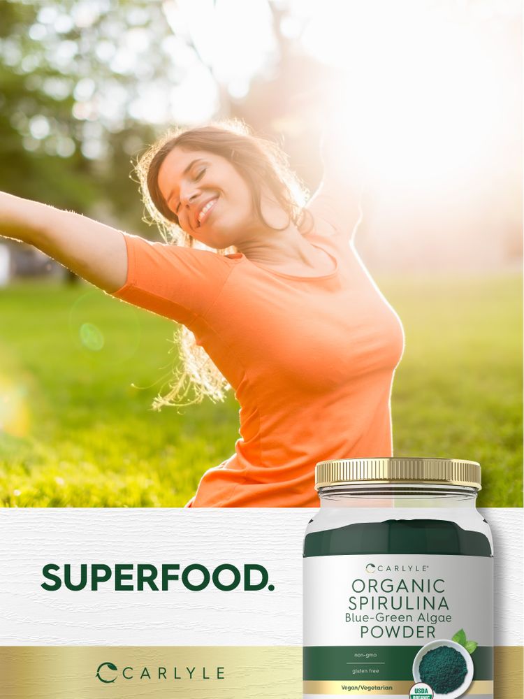 Young adult woman smiling and stretching outdoors in sunlight next to an Organic Spirulina Blue-Green Algae Powder jar.