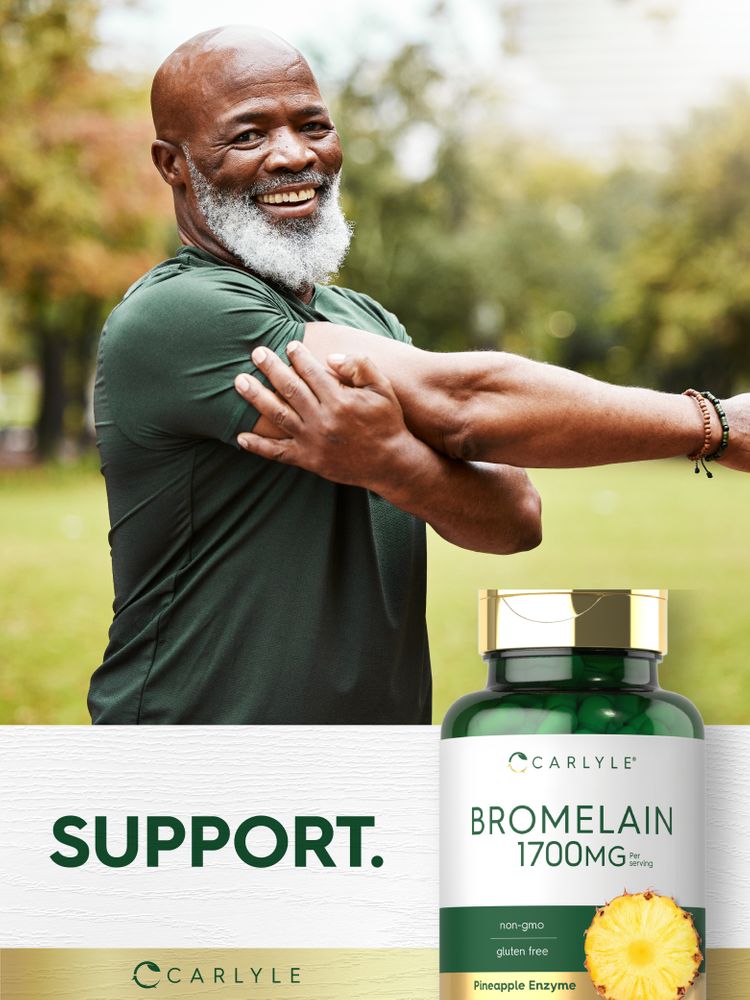 A senior Black man stretches while holding a bottle of Carlyle Bromelain.