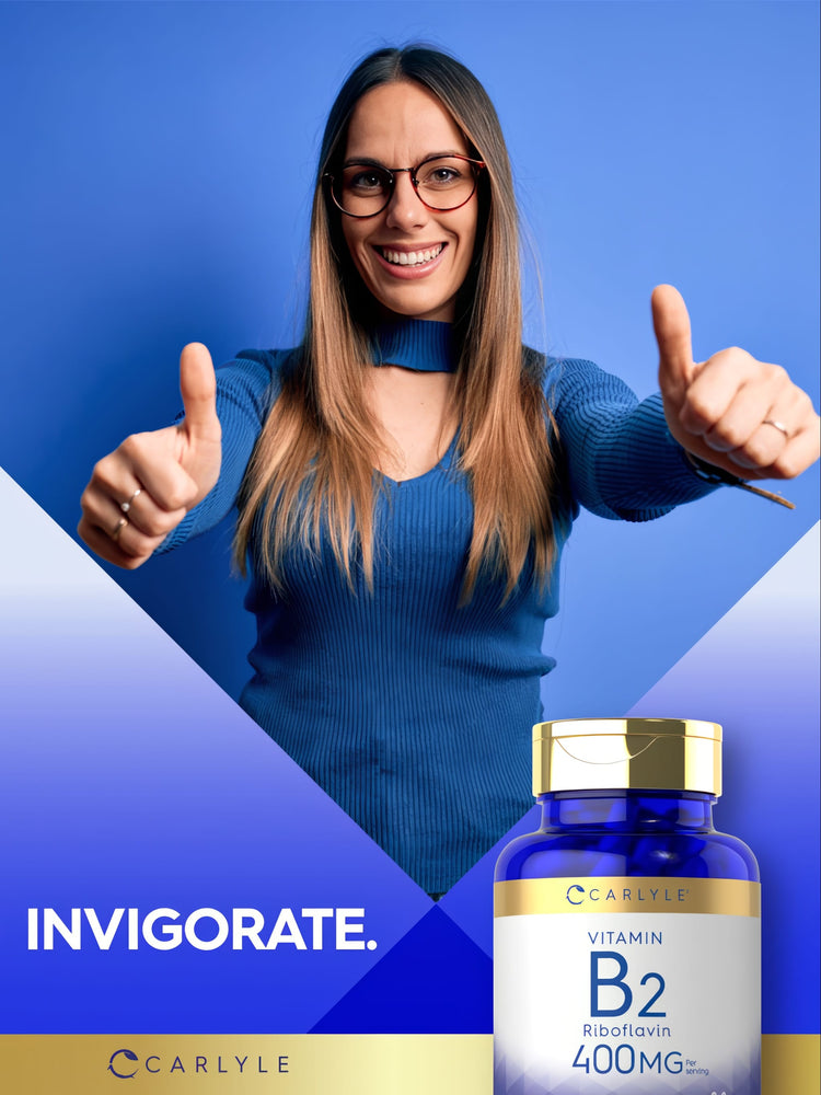 A young woman smiles and gives a thumbs up next to a Carlyle Vitamin B2 bottle.