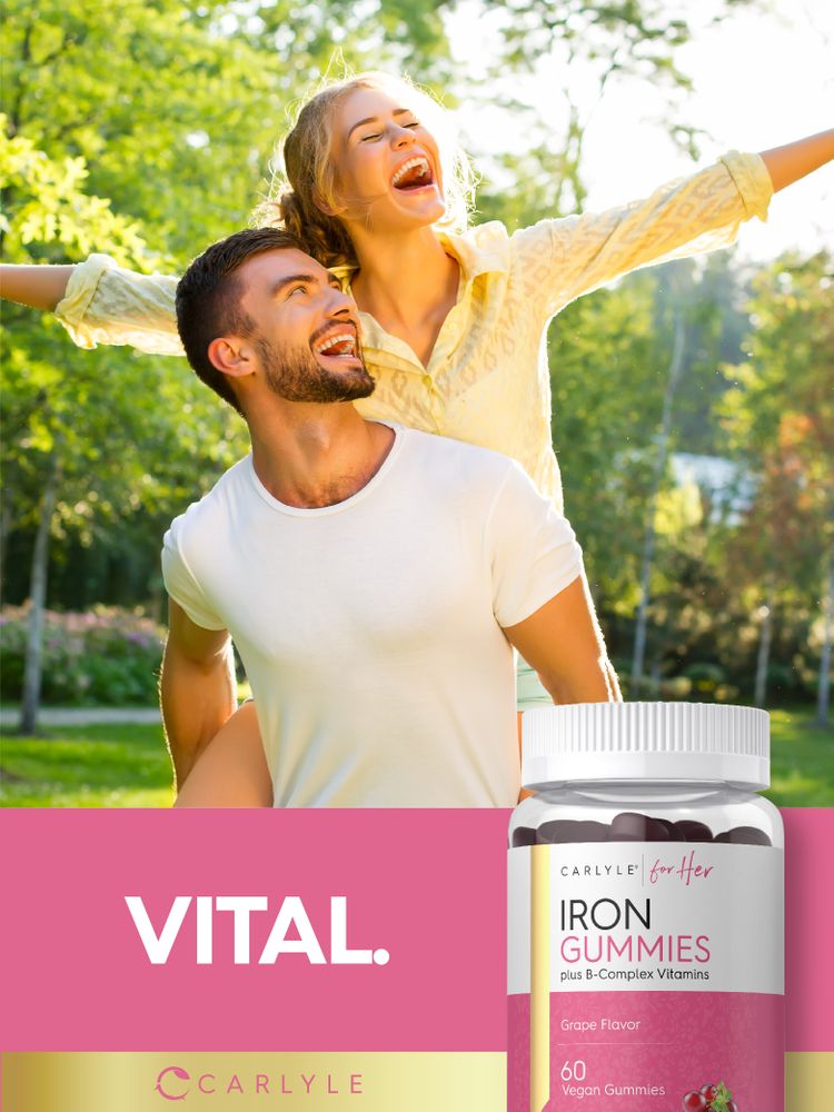 Young man gives a young woman a piggyback ride outdoors, both laughing, holding a bottle of Carlyle Iron Gummies.
