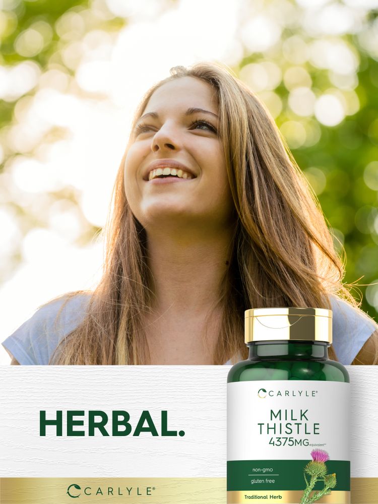 A young woman smiles and looks up outdoors with a Carlyle Milk Thistle bottle in hand.