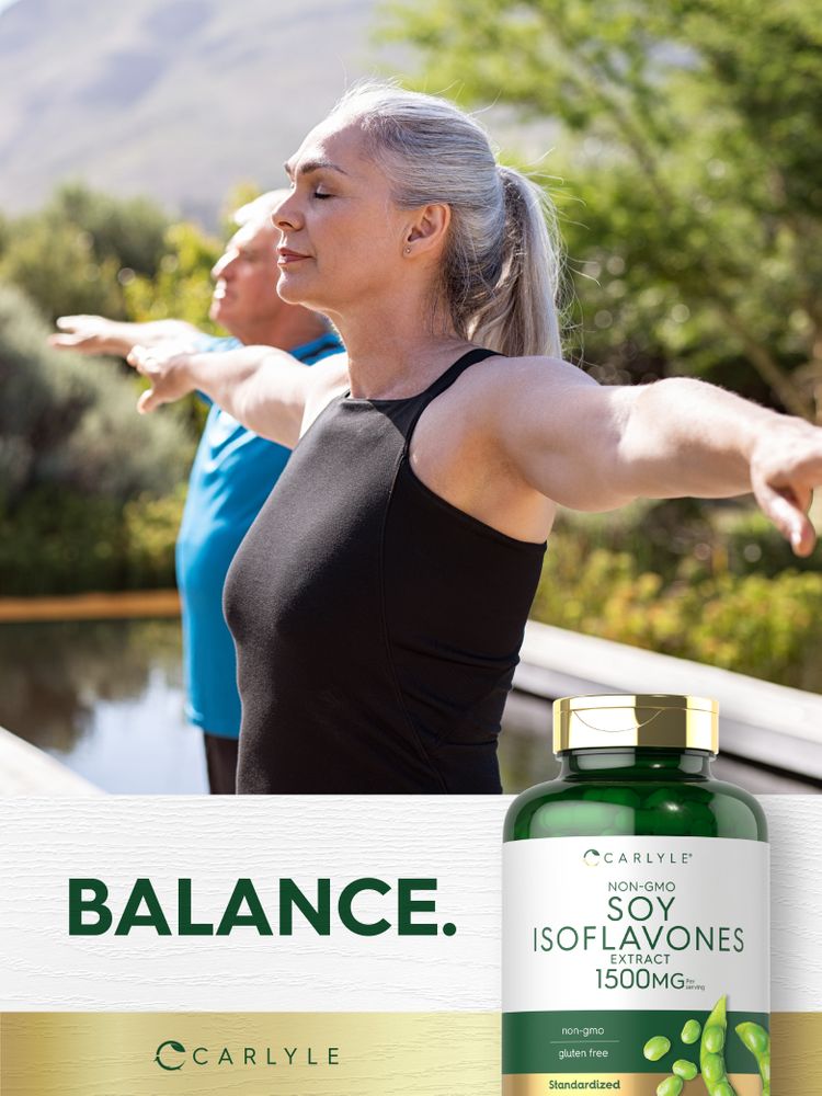 An older woman and man doing a yoga pose with arms outstretched, eyes closed, outdoors, beside a Carlyle Soy Isoflavones bottle.