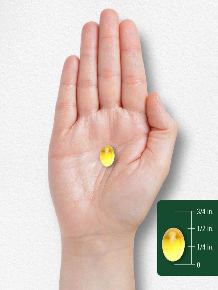 A yellow oval softgel, around 5/8 inch long, is held in an open hand for scale.